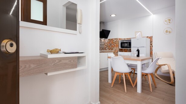 A modern kitchen with white cabinets, a microwave, and a refrigerator.