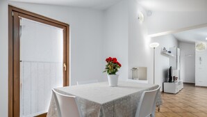A dining area with a table set for two, a potted plant, and a white chair. - 5 minutes from Lake Garda, Dimora "Charme of Butterfly (Cavaion Veronese)