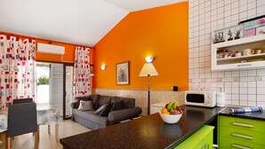 A modern kitchen with a microwave, a fruit bowl, and a green cabinet. - Vacation Home 'Haus Brigitte' with Shared Pool, Wi-Fi and Air Conditioning (Playa del Inglés)