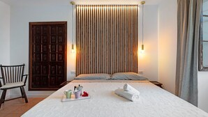 A neatly made bed with a white bedspread, a wooden headboard, and two bedside lamps. - Chalet "Casa Barreto" with Sea View, 3 Private Terraces & Wi-Fi (Puerto de la Cruz)