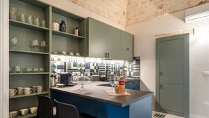 A kitchen with a central island, shelves with glassware, and a patterned floor. - Holiday Apartment "Civico40 Suite" with 2 Private Terraces, Balcony & Wi-Fi (Locorotondo)