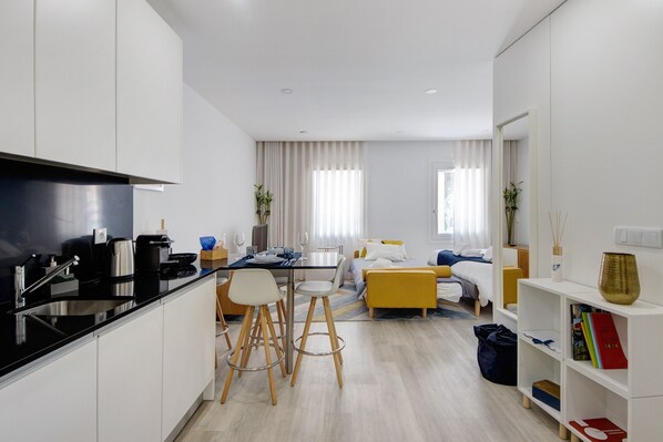 A modern apartment with a kitchen, dining area, and living room.