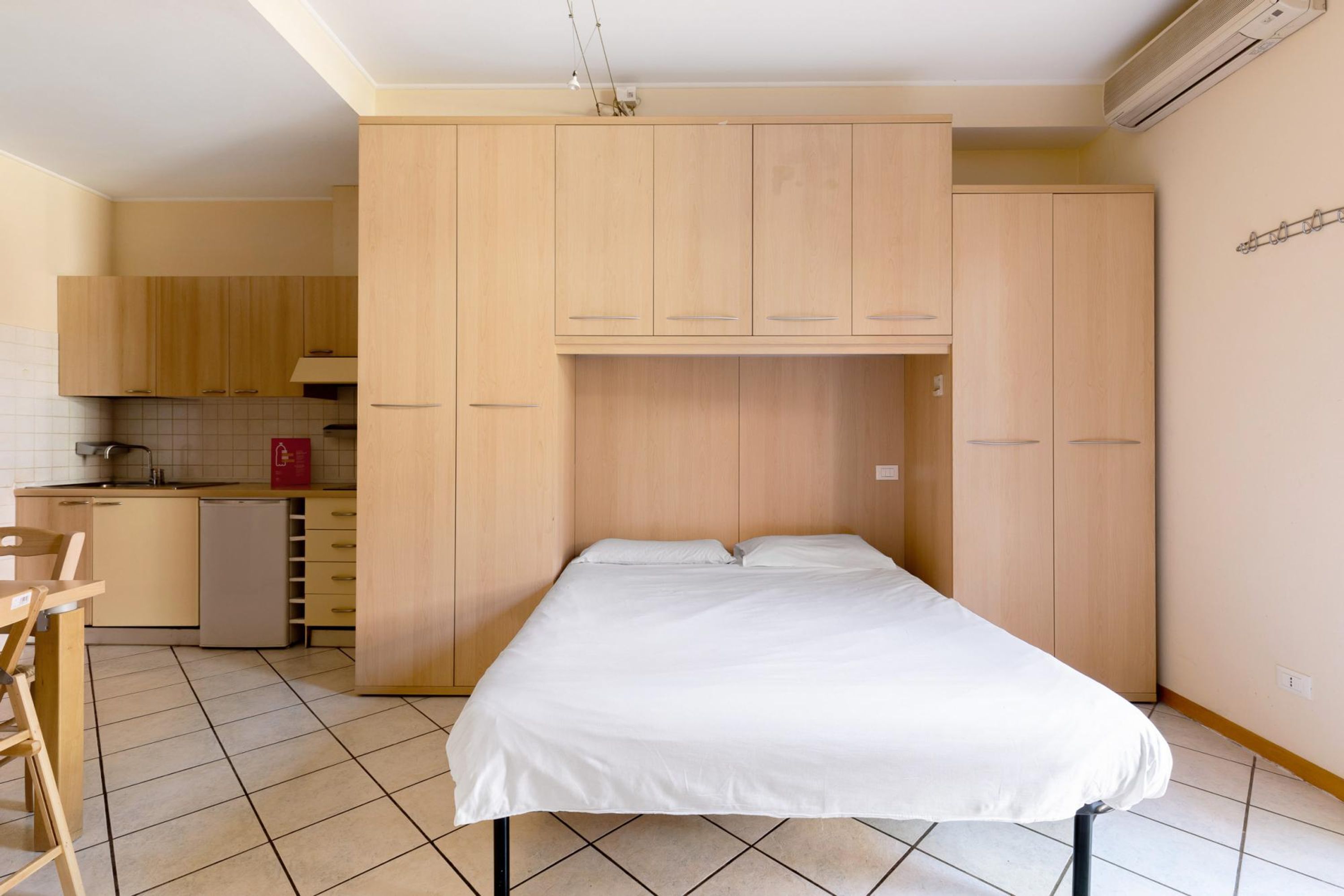 Une pièce de taille modeste comprenant un lit, une petite kitchenette et un coin repas.