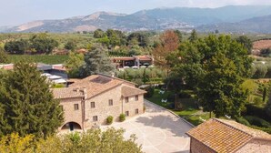 A stone building with a courtyard, surrounded by trees and hills in the background. - Mathusalem   Deluxe Suite with Spa Bath (CORI)