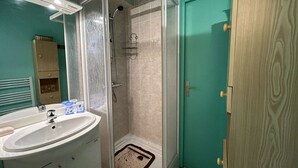 A bathroom with a glass-enclosed shower, a sink, and a cabinet. - Cozy 2-Room Apartment by the Beach with Terrace and Parking - Sleeps 4 (Saint-Jean-de-Monts)
