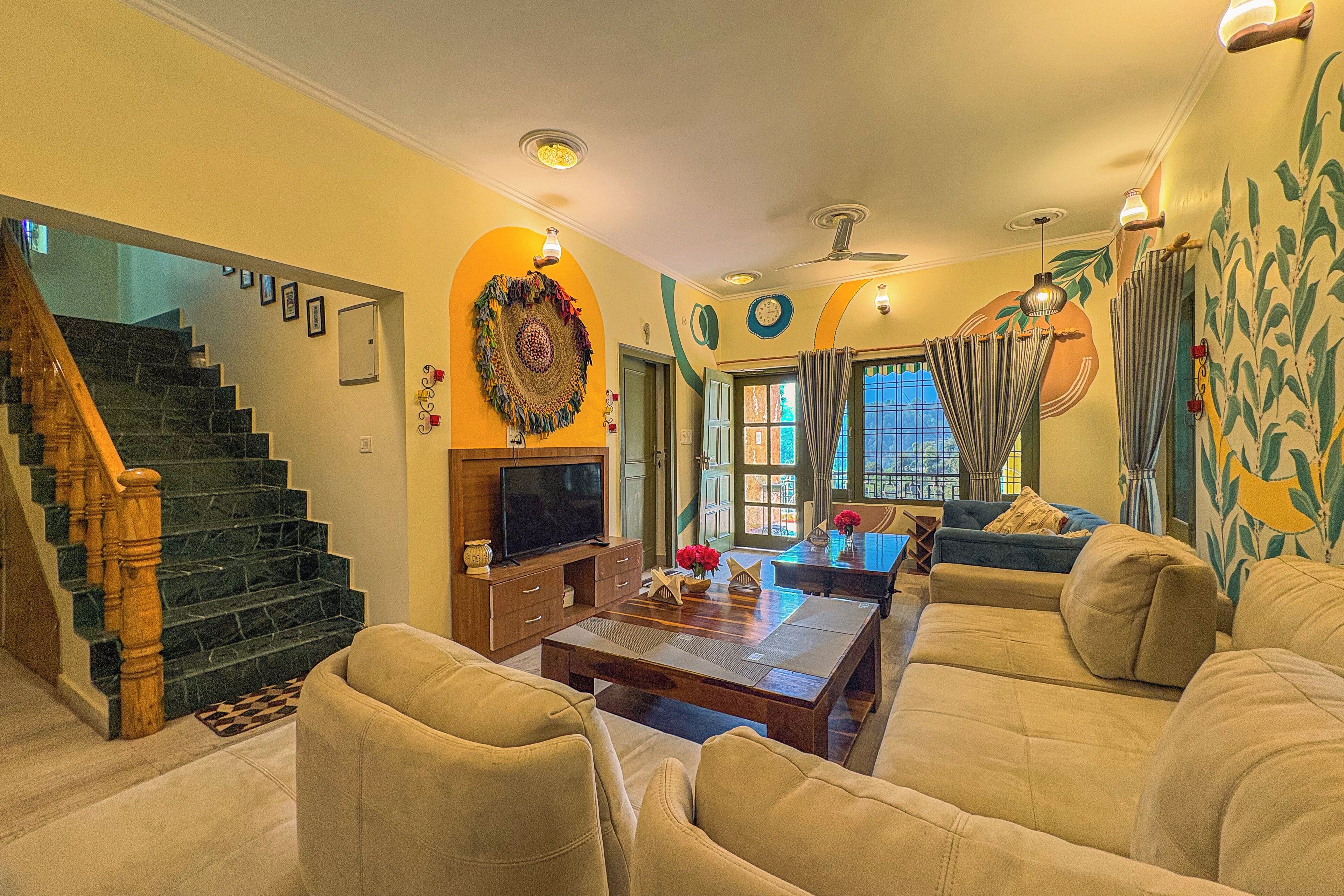 A living room with a sofa, a coffee table, a TV, and a staircase.