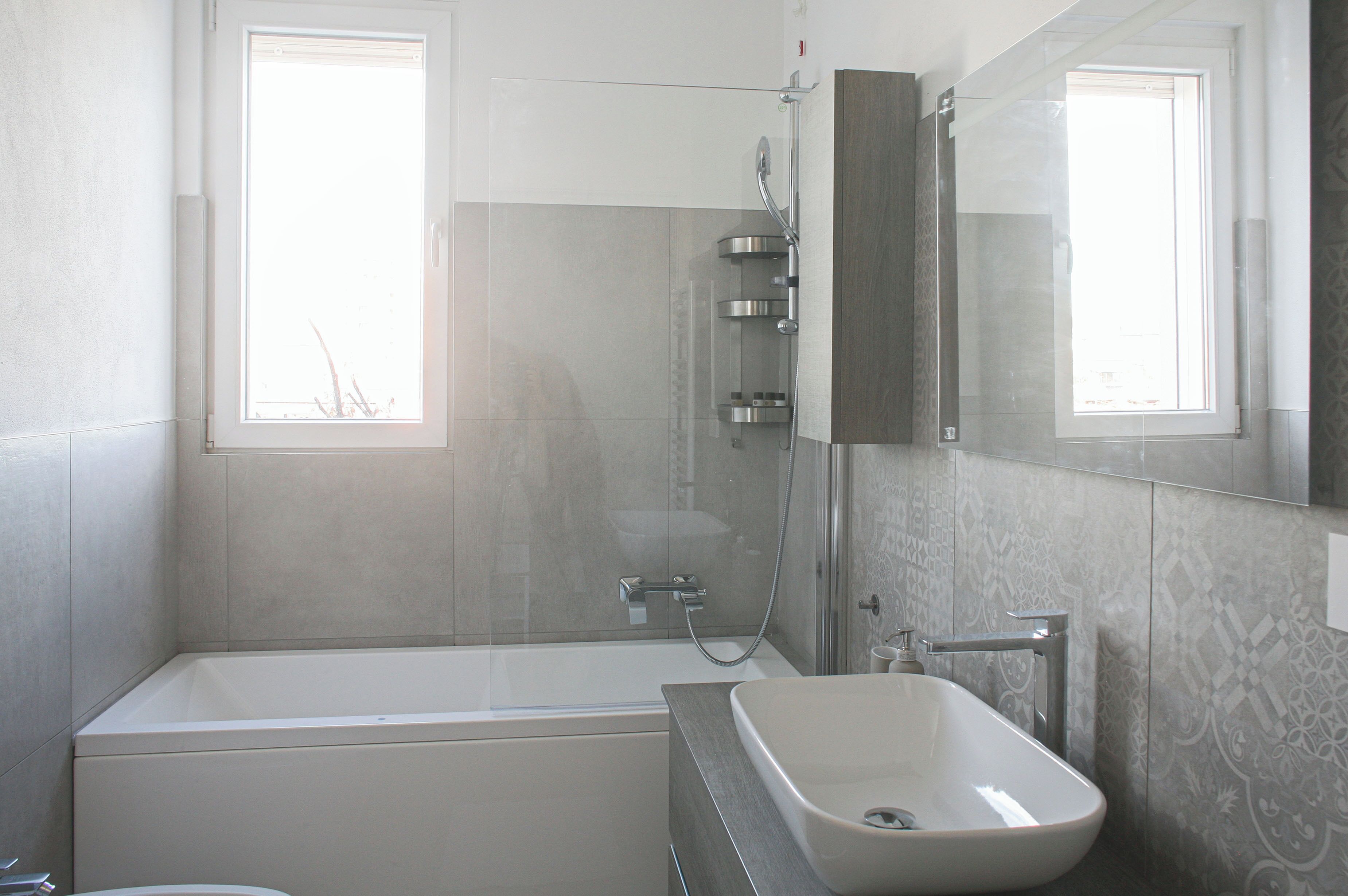 A modern bathroom with a bathtub, a sink, and a shower.