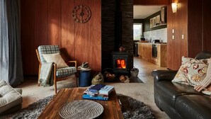 Ein gemütliches Wohnzimmer mit Kamin, Essbereich und Küche.