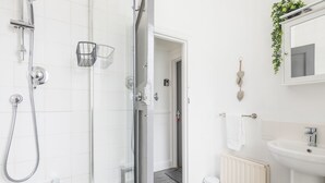A modern bathroom with a glass shower enclosure, a white sink, and a radiator. - The Modern Cambridge Studio 3 (Cambridge)