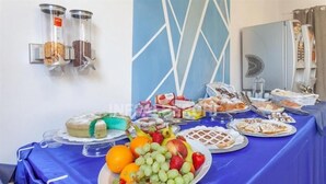 Une table de buffet proposant divers plats, notamment des fruits, des pâtisseries et un gâteau.