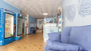 Une pièce avec un canapé bleu, un réfrigérateur et un mur orné d’un motif en forme d’aile.