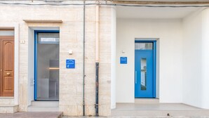 A building with two doors, one with a blue frame and another with a brown frame, both with signs indicating a location.