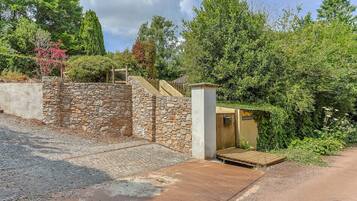 A stone wall with a wooden staircase leading to a covered area.