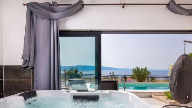 A spa area with a hot tub, a view of the sea, and a pool. - Villa Sunset view by Interhome (Senj)
