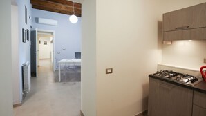 Une cuisine équipée d’une cuisinière à gaz, de meubles en bois et d’une cloison en verre transparent.