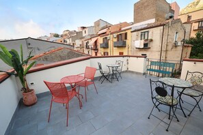 A rooftop terrace with outdoor seating, potted plants, and a view of surrounding buildings. - Case Ruggieri Luxury apt: Don Pietro apartment (Gratteri)