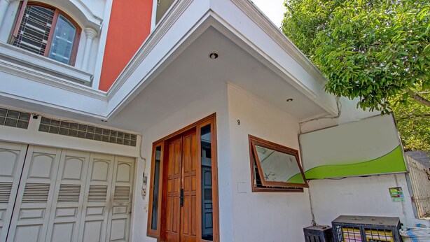 Ein zweistöckiges Haus mit Garage, einer kleinen Veranda und einem grünen Markisenvorbau.