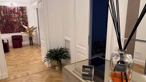 A hotel lobby with a wooden herringbone floor, a reception desk, a large abstract painting, and a potted plant. - Màs Boutique Hotel (Rome)