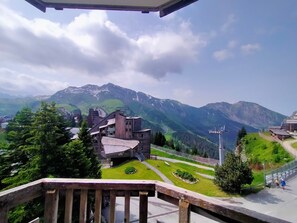 A mountainous landscape with a wooden building and a ski lift in the background.
