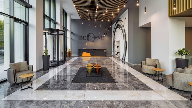 A modern reception area with a marble floor, seating, and a reception desk.