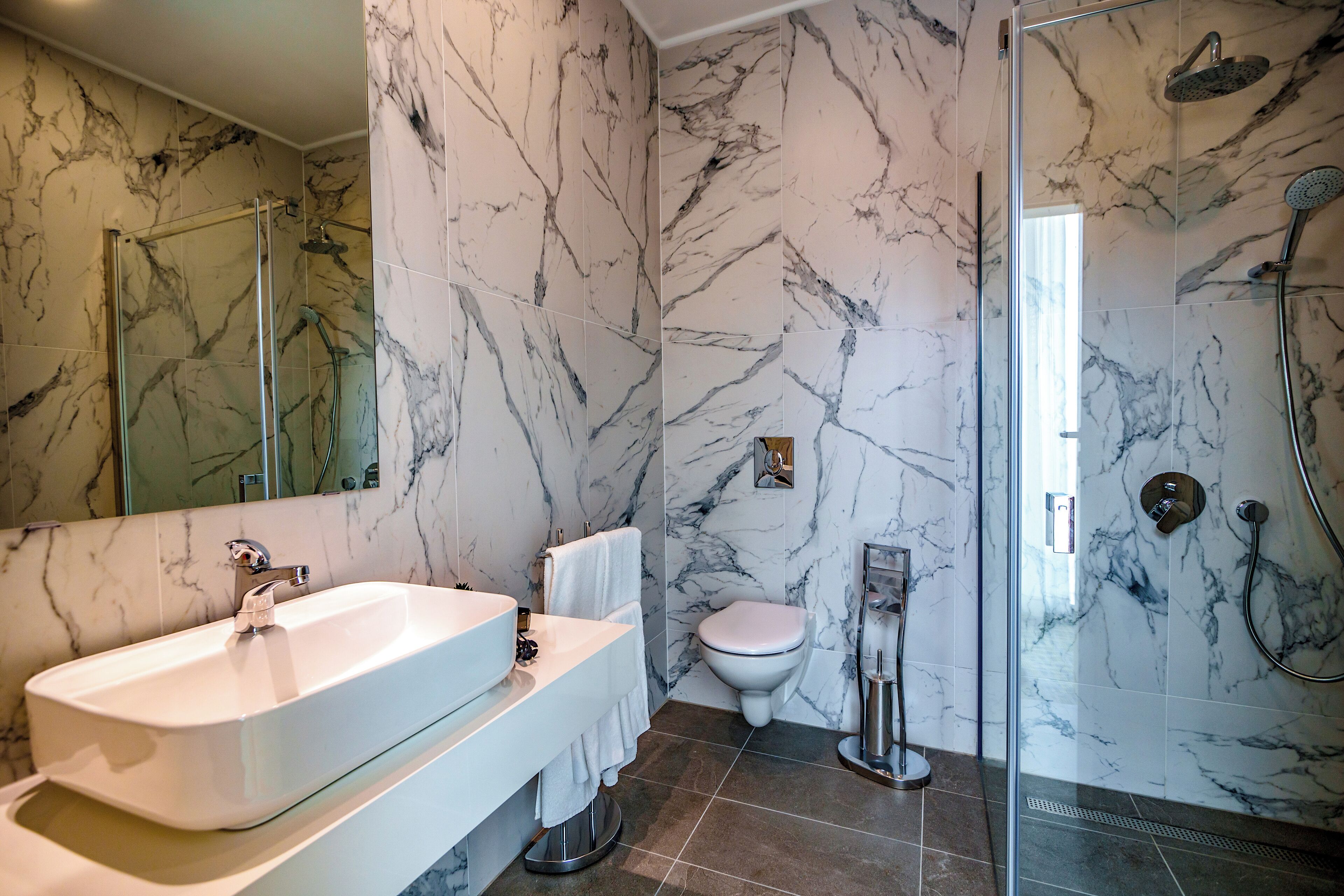 deluxe room | bathroom | shower, rainfall showerhead, hair dryer, slippers