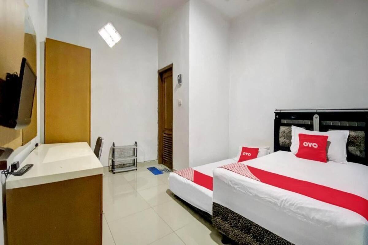 Ein Hotelzimmer mit einem Bett, einem Schreibtisch, einem Stuhl, einem Fernseher und einer Tür.