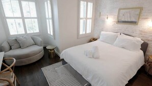 Un dormitorio con cama, una zona de estar circular y una pequeña mesa redonda.