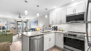 A modern kitchen with white cabinets, stainless steel appliances, and pendant lighting. - Ocean Forest Villas Unit D215 - Ocean view (Myrtle Beach)