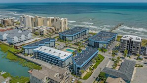 Un hôtel situé sur la côte, composé de plusieurs bâtiments, doté d’un parking et offrant une vue sur l’océan.