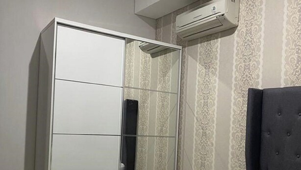A hotel room with a bed, a wardrobe, and an air conditioning unit. - Hotel O Aida Lestari (Sebulu)