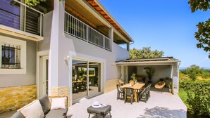 A modern two-story house with a patio area featuring outdoor furniture and a dining table. - Beautiful home in Suze-La-Rousse (Suze-La-Rousse)