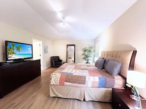 A bedroom with a bed, a television, a mirror, and a potted plant. - Near Disney | Conservation View & Pool Spa 588 (Davenport)