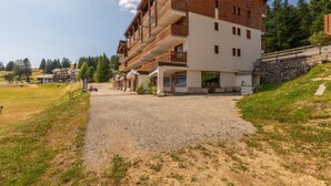 Ein mehrstöckiges Hotel mit einer Auffahrt aus Kies zum Eingang.