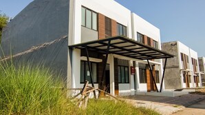 A modern building with a covered entrance, large windows, and a sign indicating it is a hotel. - OYO 3826 Columbus Residence K11 (Karawang)