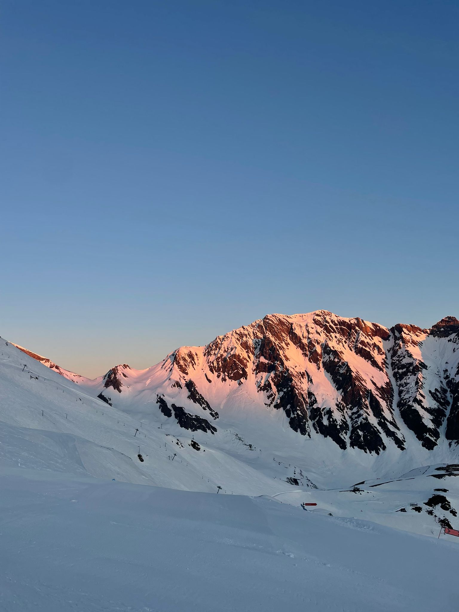 A snow-covered mountain landscape with clear skies.