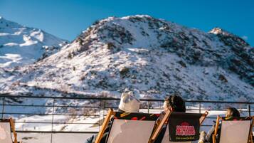 Une personne est en train de peindre sur un chevalet, avec une montagne en arrière-plan.