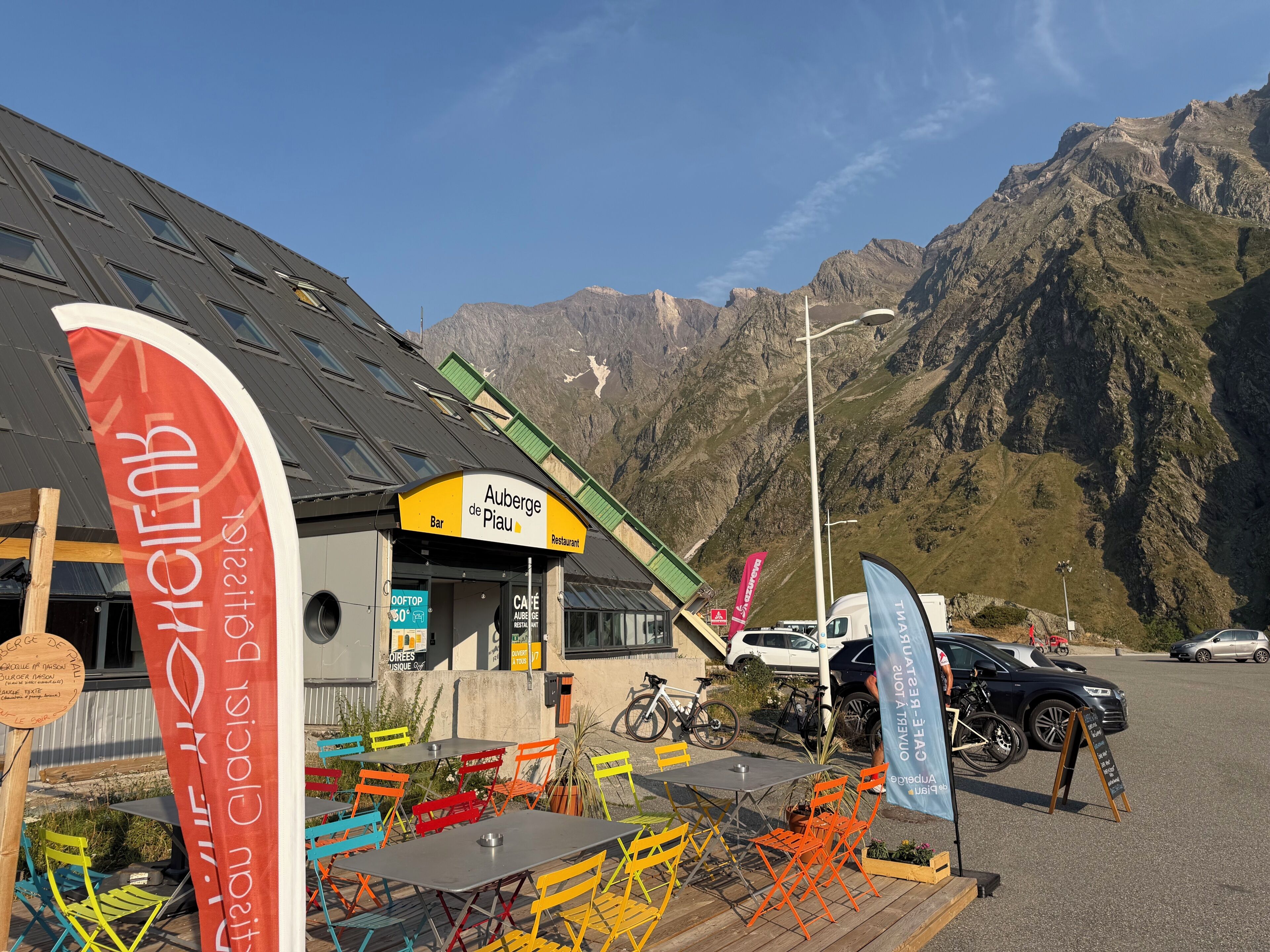A mountain restaurant with outdoor seating and a view of the surrounding mountains.