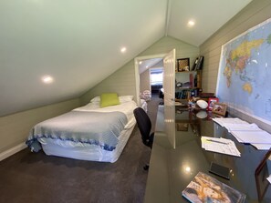 A bedroom with a bed, a desk, a chair, a map on the wall, and a door leading to another room. - 6 bed, 4 bath, 3 level renovated Barn, 1400m to Bowral centre, 320m2, peaceful. (Bowral)