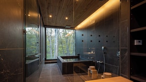 Un baño moderno con una bañera grande, una zona de ducha separada y un tocador.