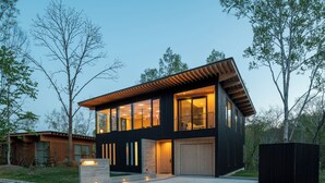 A modern two-story house with large windows, a garage, and a well-maintained lawn. - Yuki Sugi at Intuition (Kutchan)