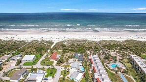 An aerial view of a coastal residential area with houses, a beach, and a swimming pool. - Surf Drive Paradise – Oceanview Pool Home Just Steps from the Beach (St. Augustine Beach)