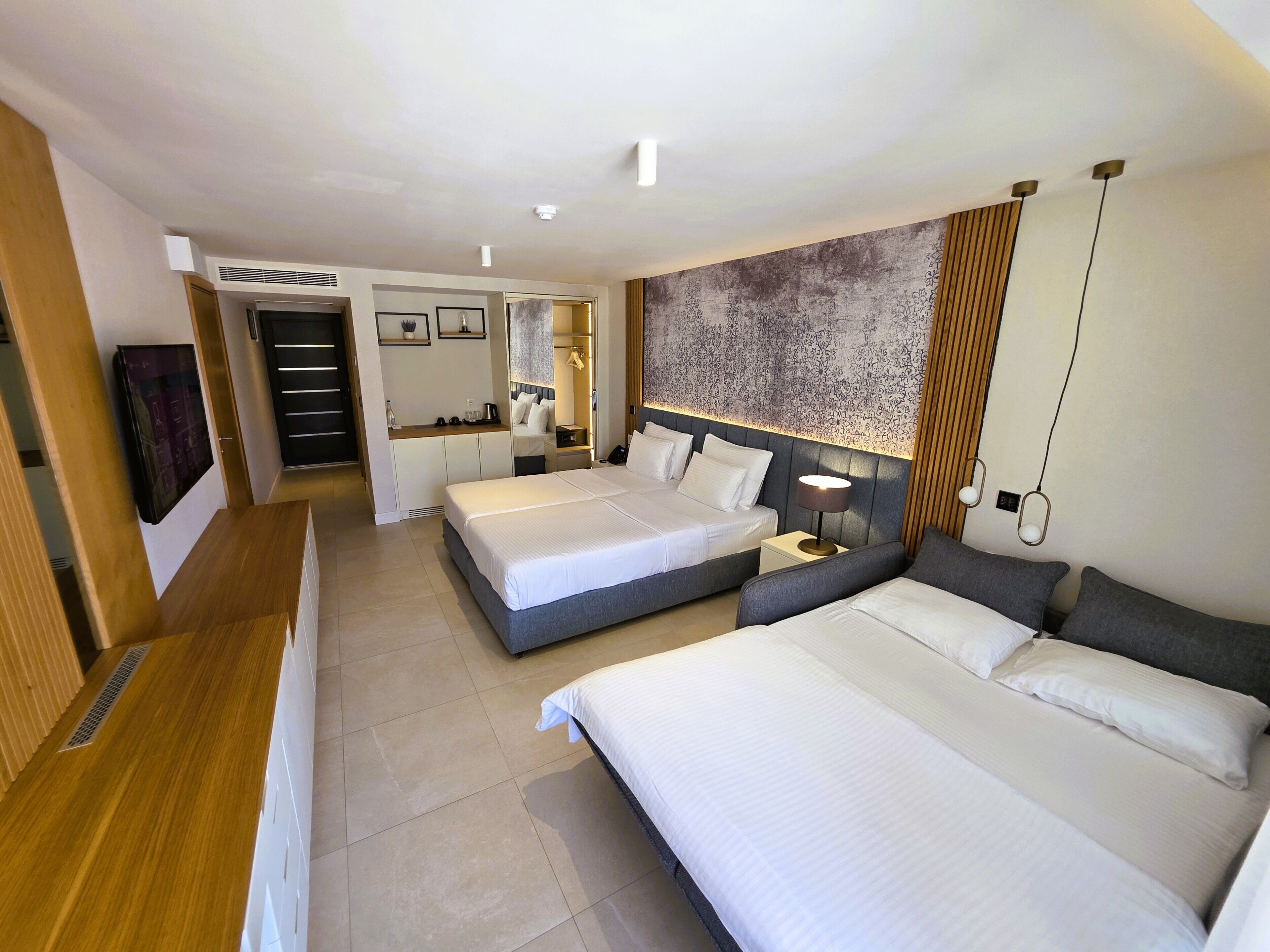 Une chambre d’hôtel avec deux lits, un bureau, une armoire et une salle de bain.