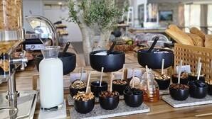 A buffet setup with various food items and a milk dispenser.
