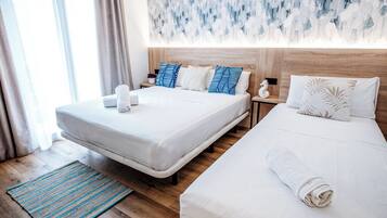 Habitación de hotel con dos camas, cabecero de madera, cuadro abstracto azul en la pared y alfombra a rayas.