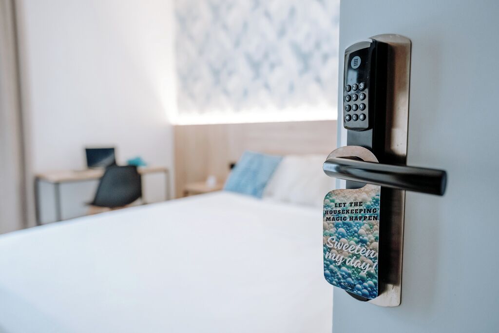 Puerta de habitación de hotel con cerradura electrónica y un cartel de motivación.