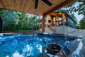 A hot tub area with a wooden ceiling and a stone wall. - Arcade Game, Board Games, Hot Tub, Fire Pit, Pets, Manhattan (Broken Bow)