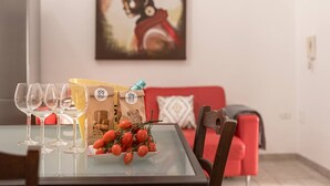A dining table with wine glasses, a plate of cherry tomatoes, and two paper bags with the number 83. - Casa Mila (Ostuni)