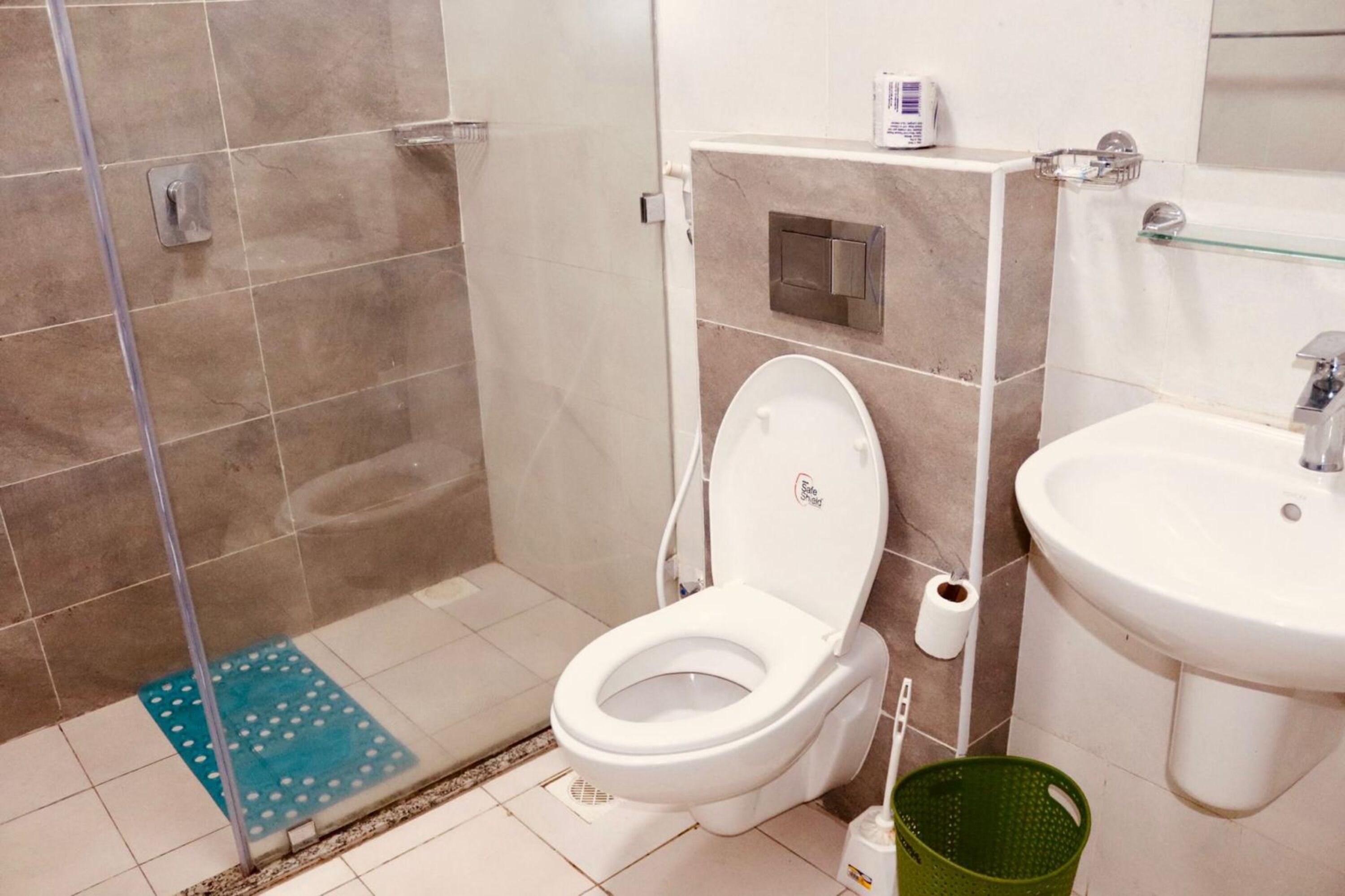 Een badkamer met toilet, wastafel en douche.