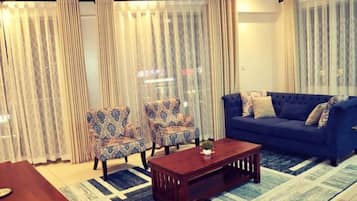 Apartamento Deluxe | Zona de estar | Televisión de pantalla plana de 42 pulgadas con canales digitales