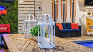 A wooden table with two white wicker lanterns and a small plant. - 13SC Beach, Private Pool, 10 foot movie theater screen (Hilton Head Island)